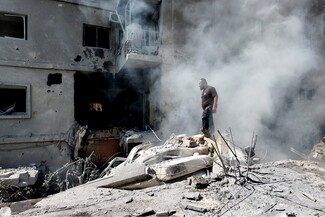 A man stands amid the smoke and atop the rubble of a building that collapsed following the Israeli strike on the Hay al-Raml/al-Raml neighborhood in Sur. South Lebanon, Lebanon. April 8, 2026.