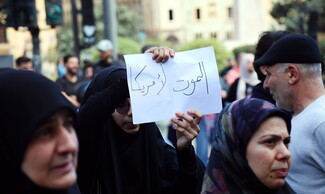 A demonstrator clad in black holds up a sign that reads: “Death to America.”