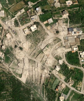 Aerial view of a residential area with extensive building rubble and debris.