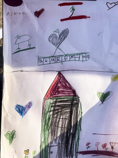 A colorful drawing signed "Asmaa" showing a Lebanese flag, simple bird doodles, a letter grid, and a house surrounded by hearts and flowers.