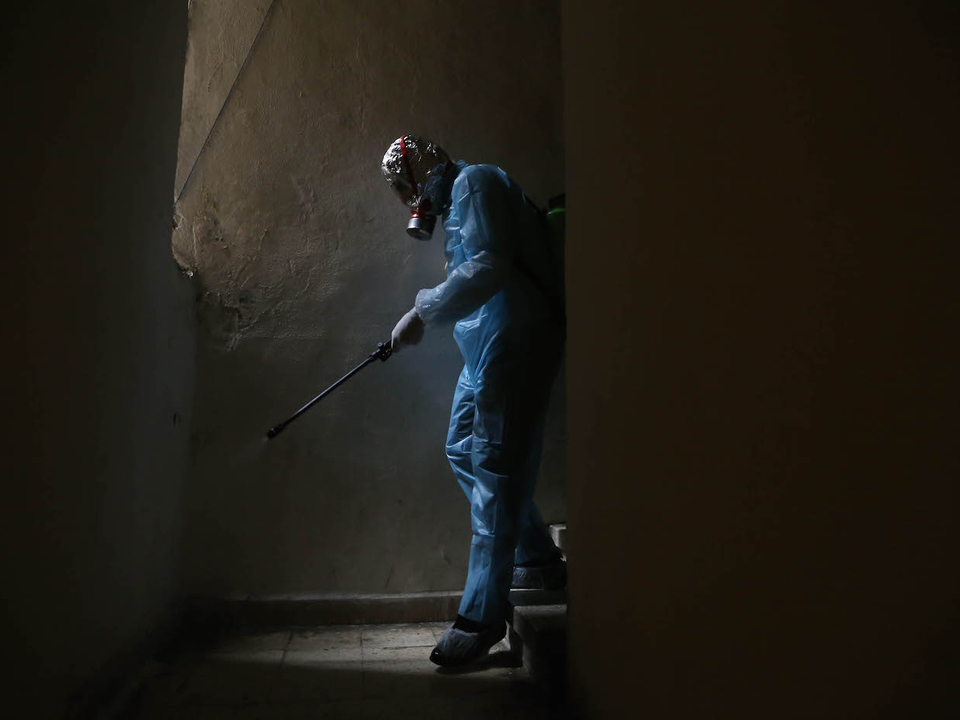 A volunteer health worker disinfects a building in Ras Beirut. Beirut, Lebanon. March 20, 2020. (Hussein Baydoun/The Public Source)