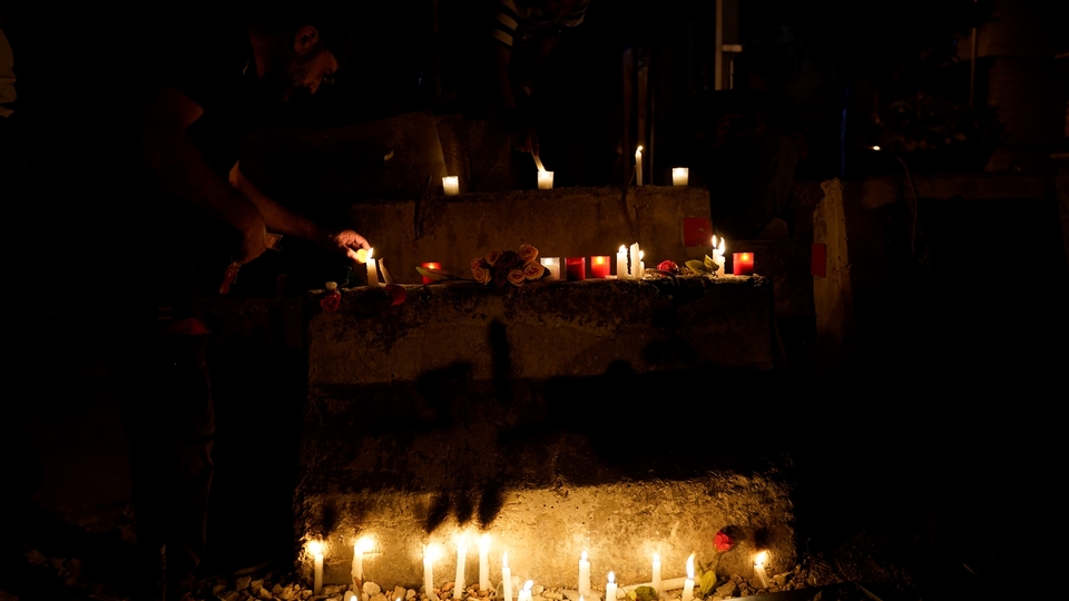 محتجّون خلال وقفة لإضاءة الشموع من أجل عاملان سوريان قُتلا عندما أضرم متظاهرون النار في مبنى قريب خلال احتجاجات ضد الحكومة تحولت الى شغب. وسط بيروت، لبنان. ٢٠ تشرين الأول ٢٠١٩ (محمد شبلاق، مصدر عام)