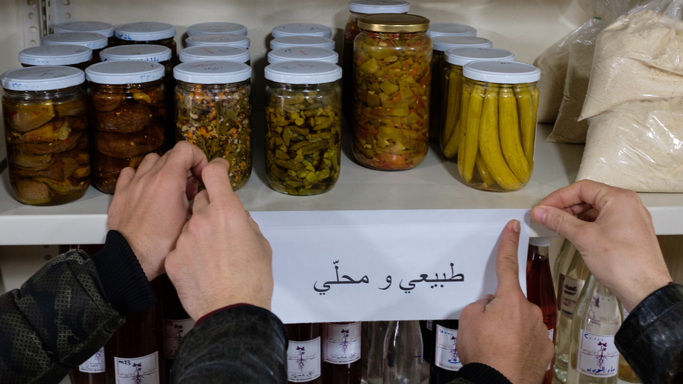 Shopkeepers hang a sign for "natural and local" pickled items. April 16, 2021. (Rita Kabalan/The Public Source)