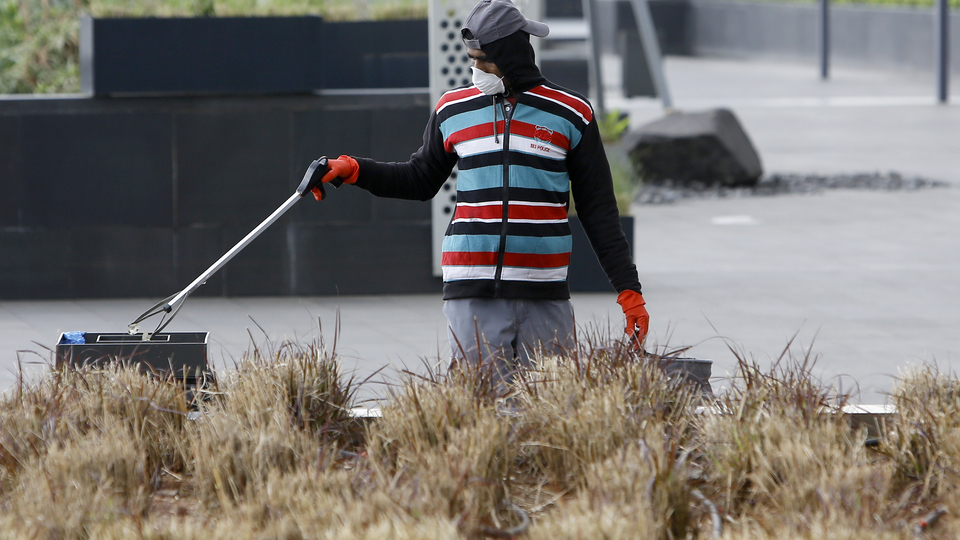 A street sweeper wearing a mask is cleaning empty streets. Beirut, Lebanon. March 18, 2020. (Marwan Tahtah/The Public Source)