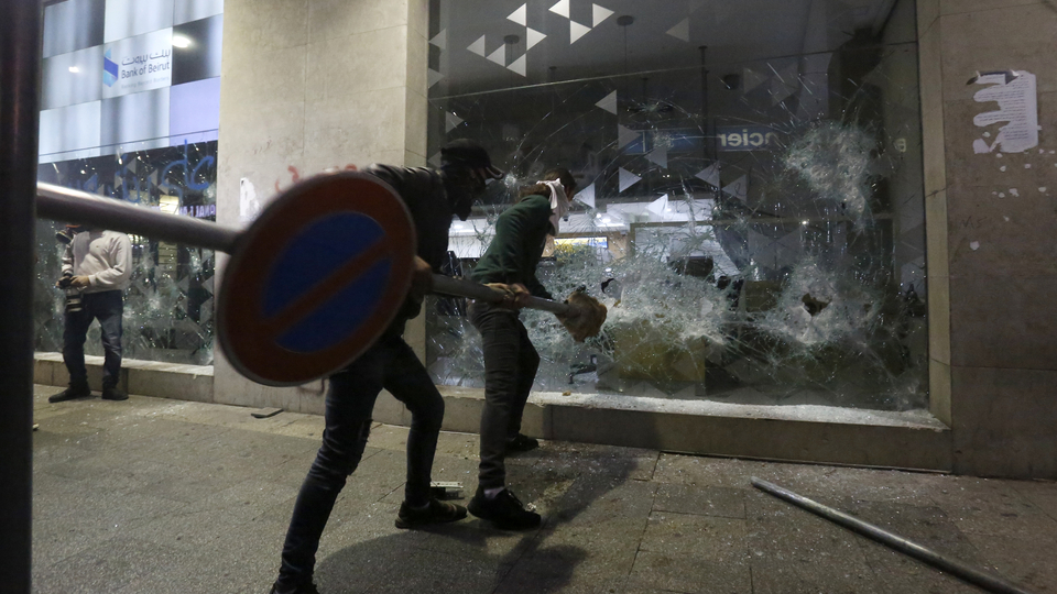 Protesters smash the storefront of Bank of Beirut’s branch on Hamra St. during the "Night of the Banks." Beirut, Lebanon. January 14, 2020. (Marwan Tahtah/The Public Source)