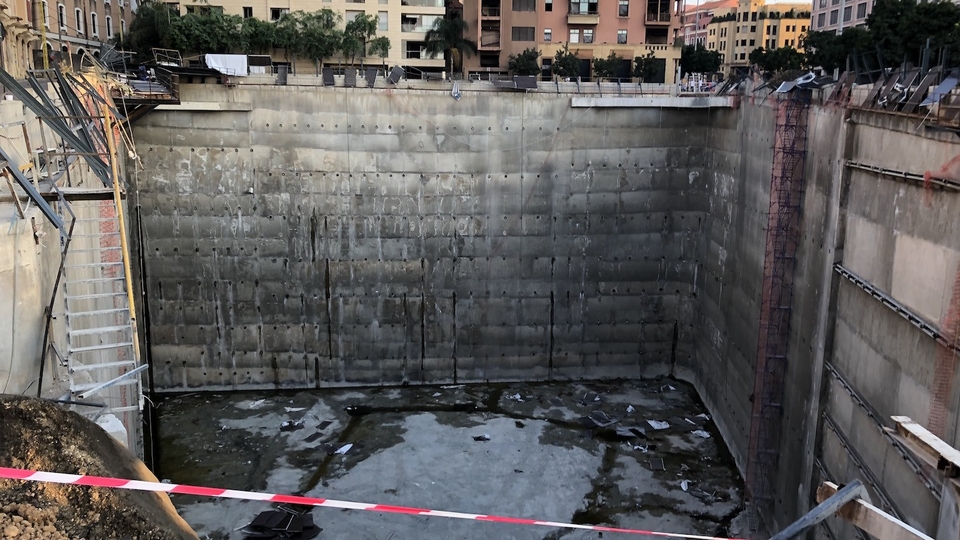 A gaping pit in the ground, tens of meters deep, left by the removal of the ruins of a well-preserved Roman-era neighborhood to make way for a bank tower that never was.